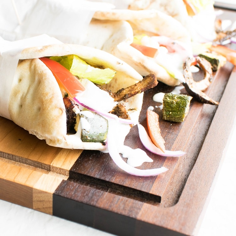 A front view of vegan gyros on a wooden board