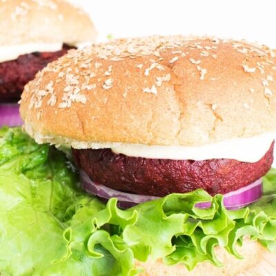front view of 2 spicy beet burger on a wooden board