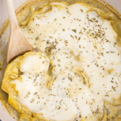 A wooden spatula picking up nut free vegan scalloped potatoes