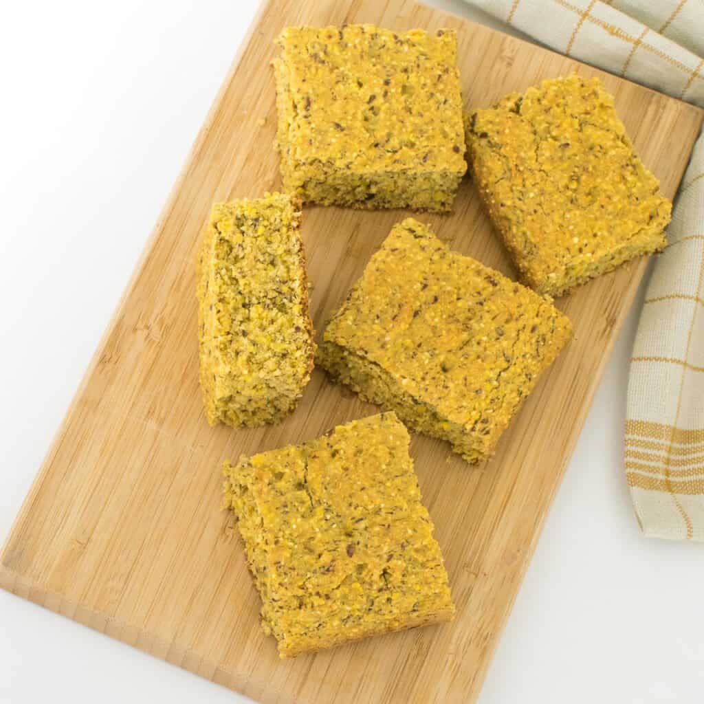 top view of sliced vegan cornbread on a wooden board.