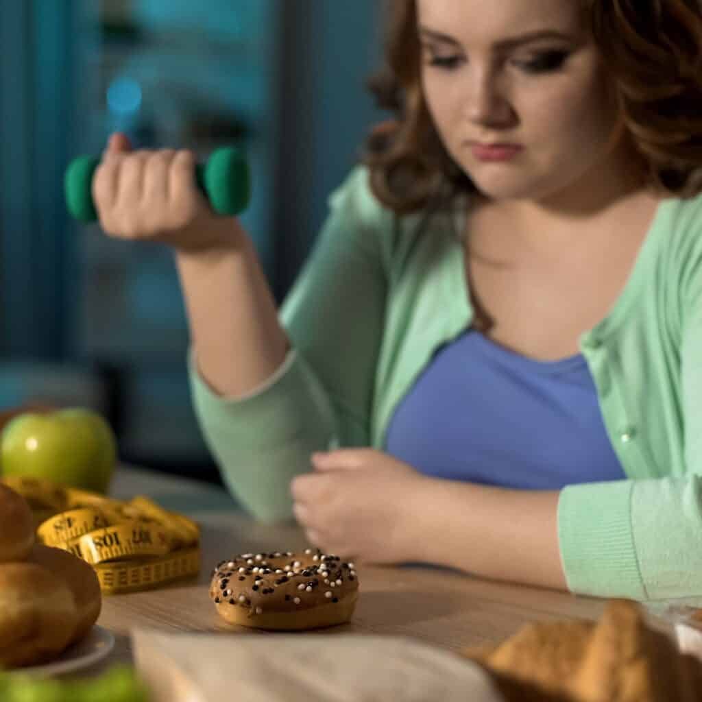 An overweight lady contemplating her dilemma for eating when under stress.