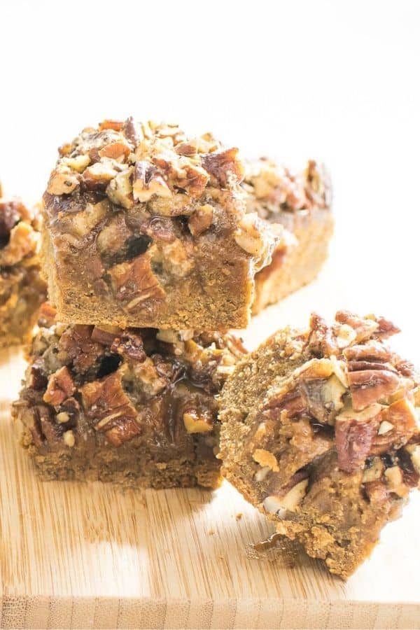 Sliced pecan pie bars on a wooden board.