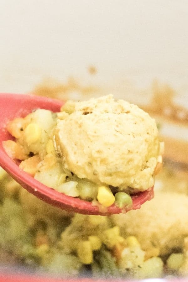 a spatula picking up vegan pot pie with chickpea flour biscuits.