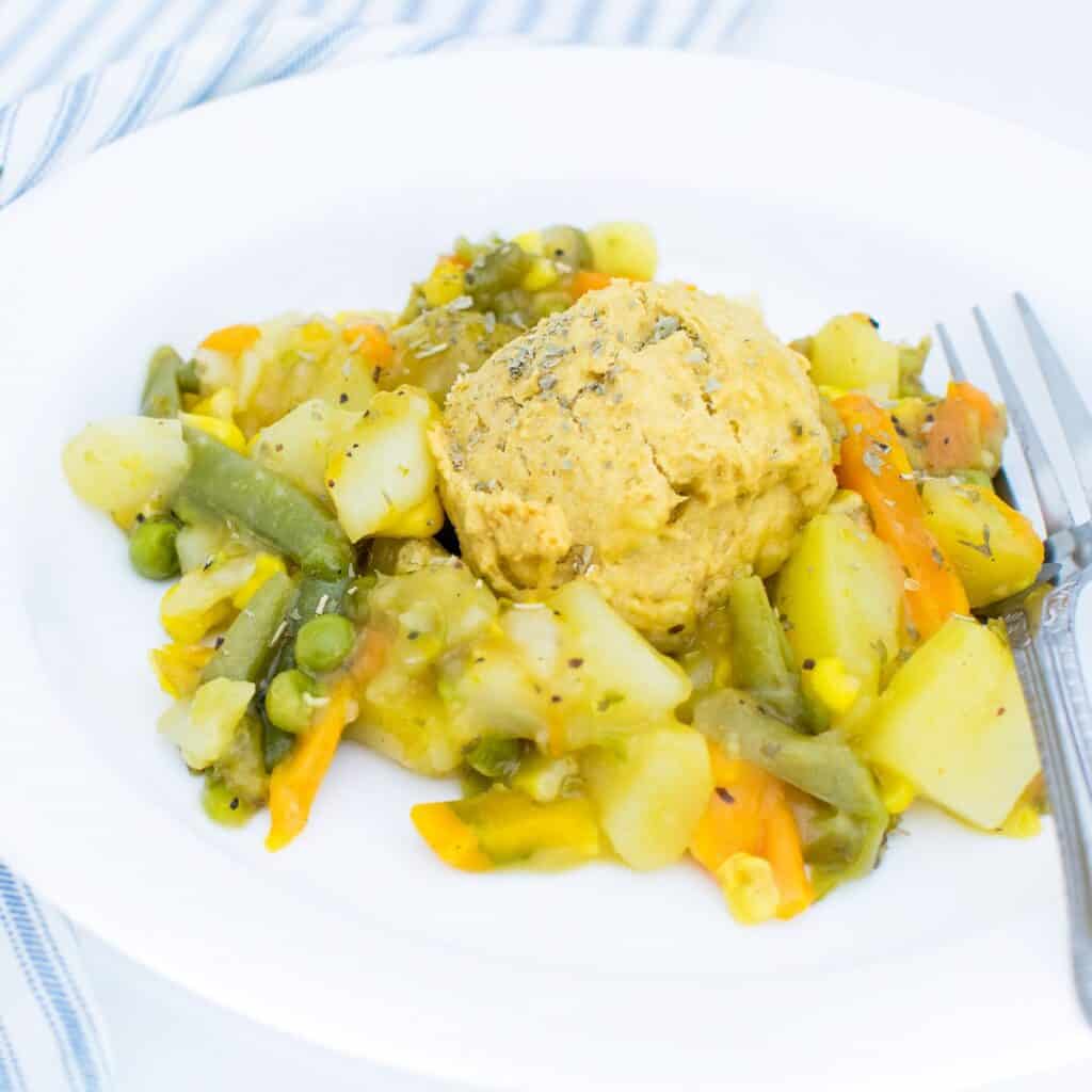 a 45 degree angle view of vegan pot pie with chickpea flour biscuits.