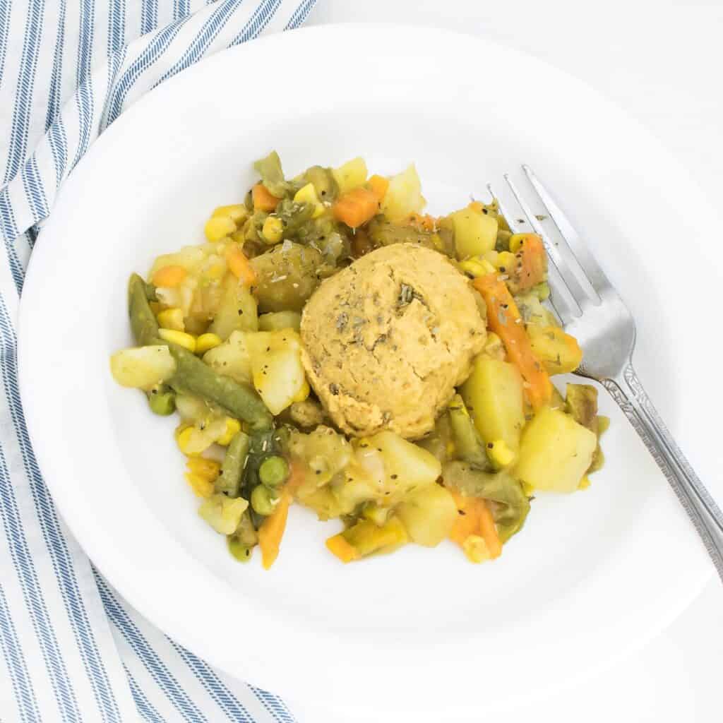 vegan pot pie with chickpea flour biscuits in a serving plate.