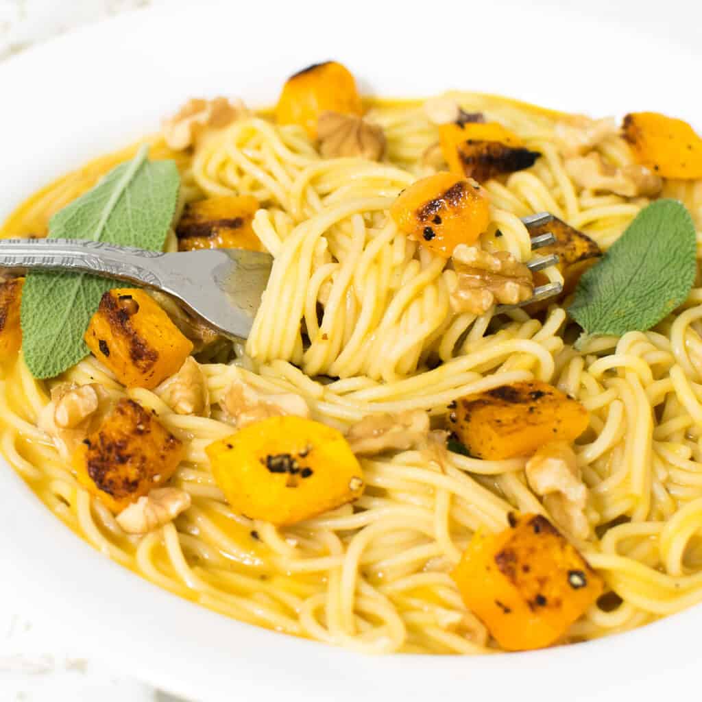 a fork with butternut squash pasta with a close up view.