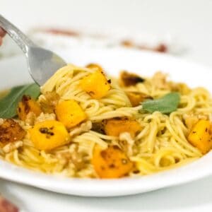 A fork rolling in butternut squash pasta.