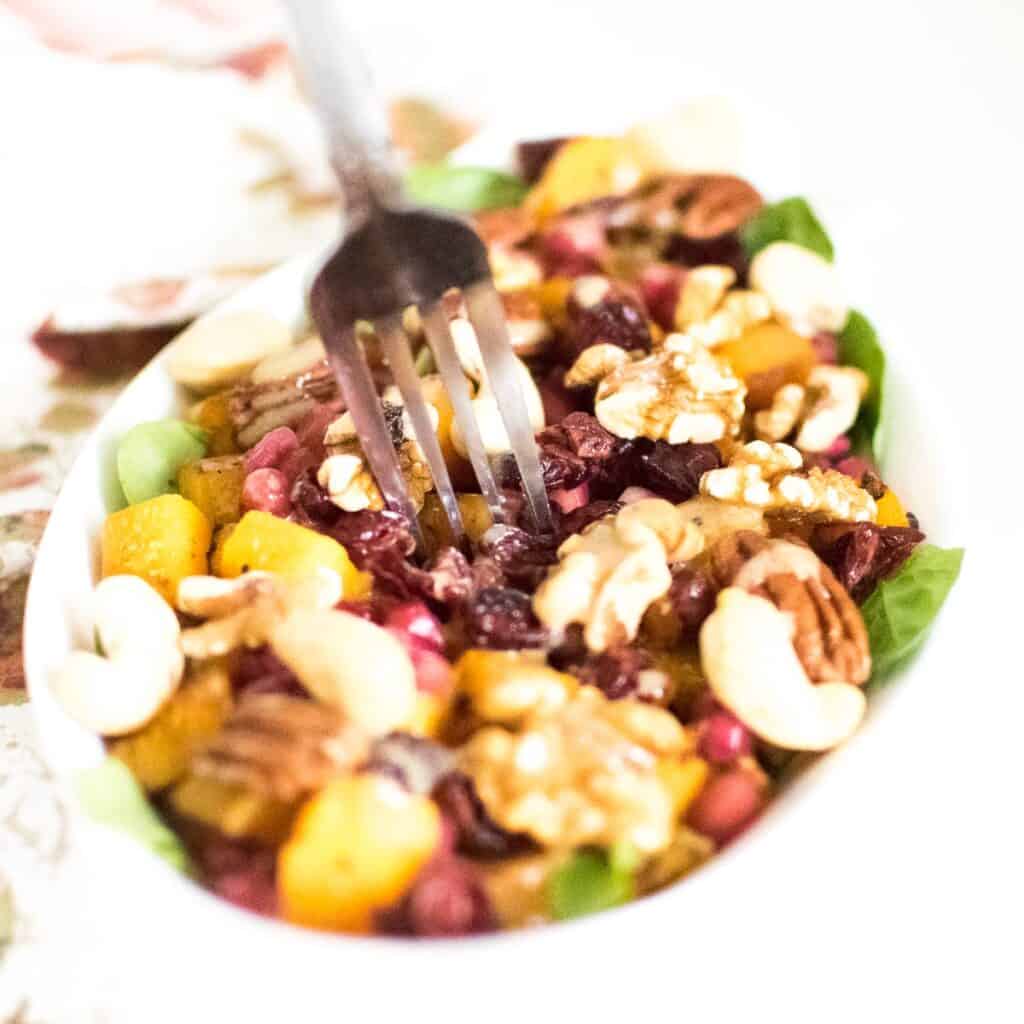 a fork digging into butternut squash salad.