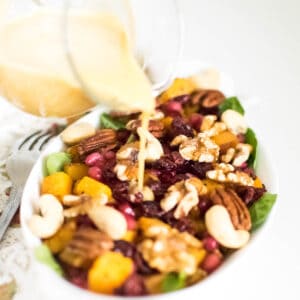 dressing pouring over butternut squash salad