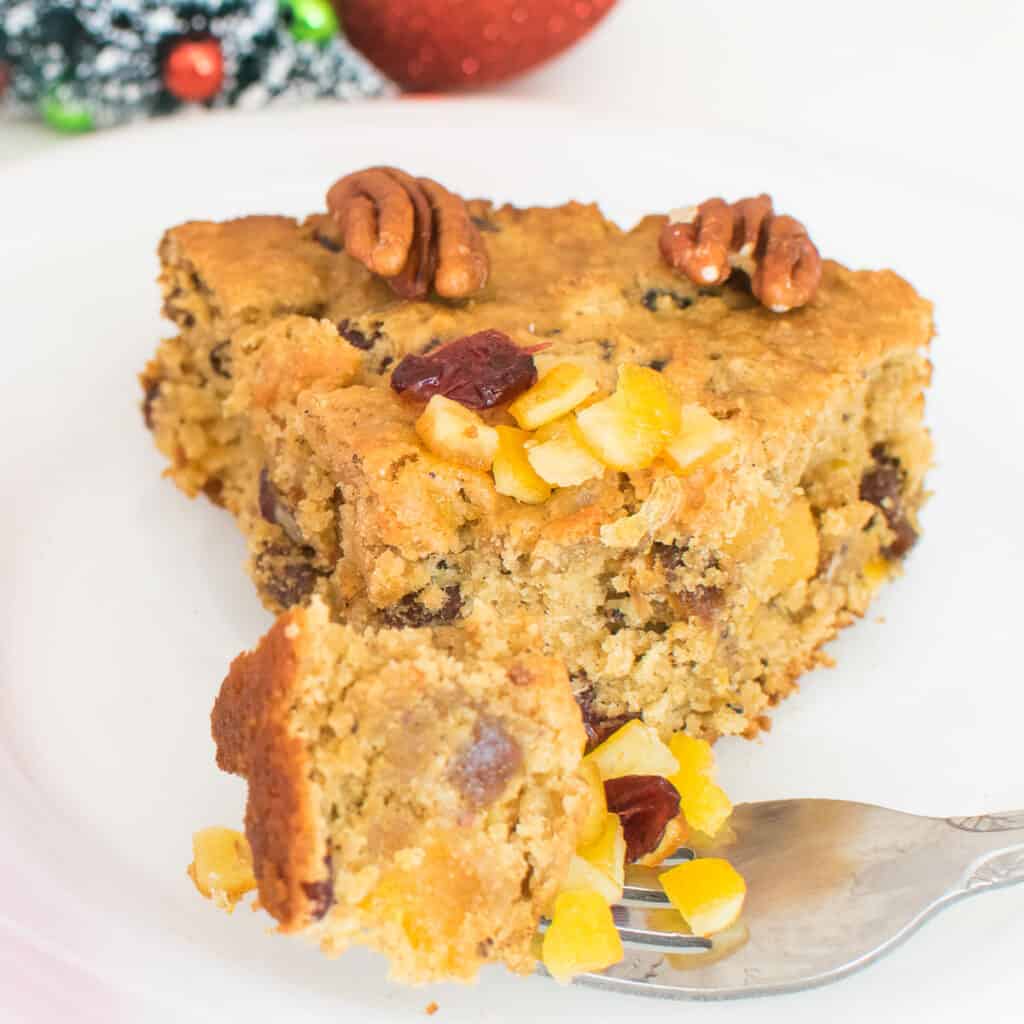 a fork with a bite of Christmas fruit cake.