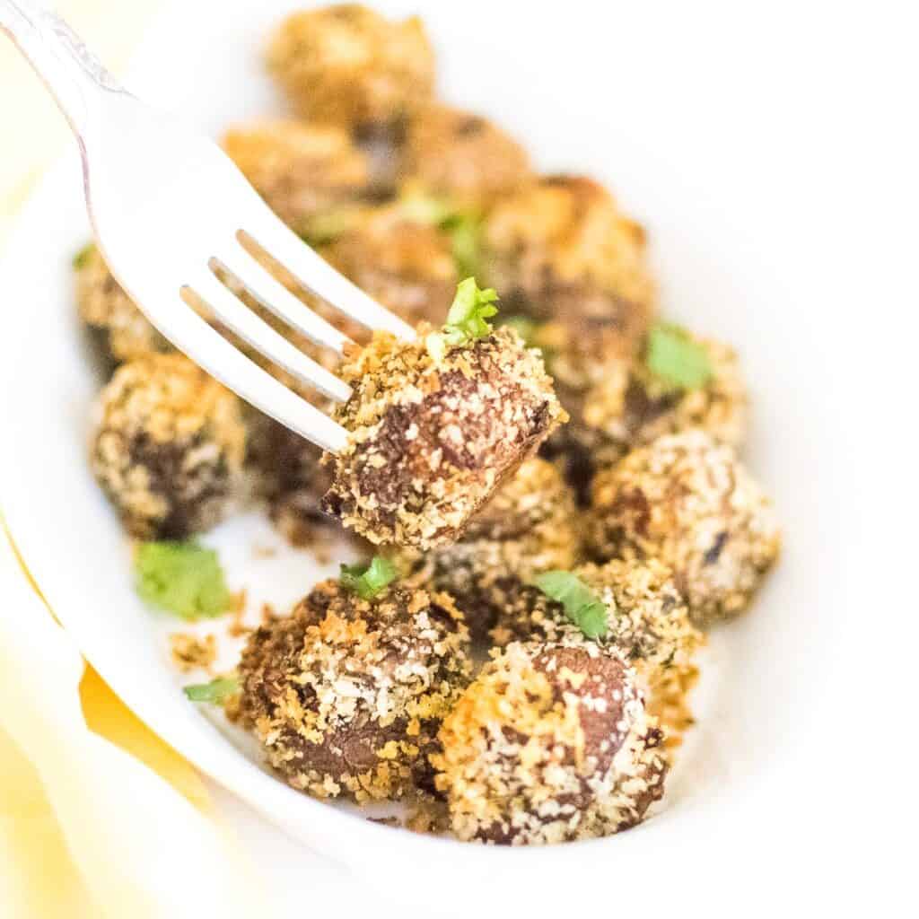 a fork picking up air fryer mushrooms.