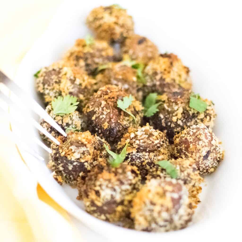 a fork digging into air fryer mushrooms.