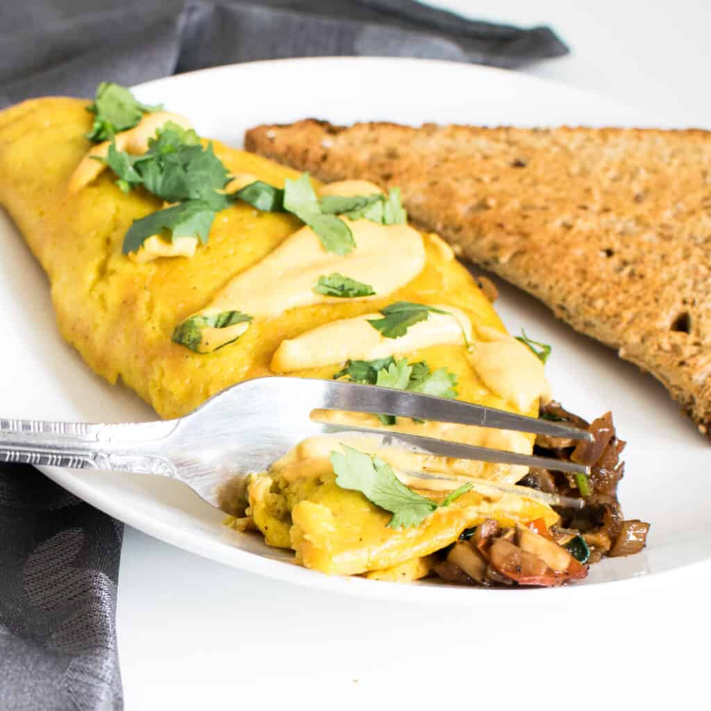 a fork digging through vegan omelette.