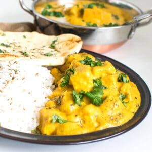 A front view of butter tofu served with rice and naan.