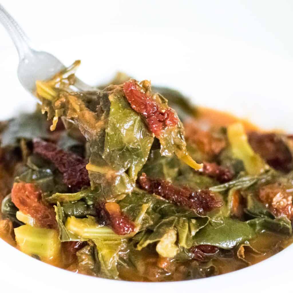 a fork scooping out vegan collard greens