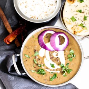top view of dal makhani in kadai with rice and naan
