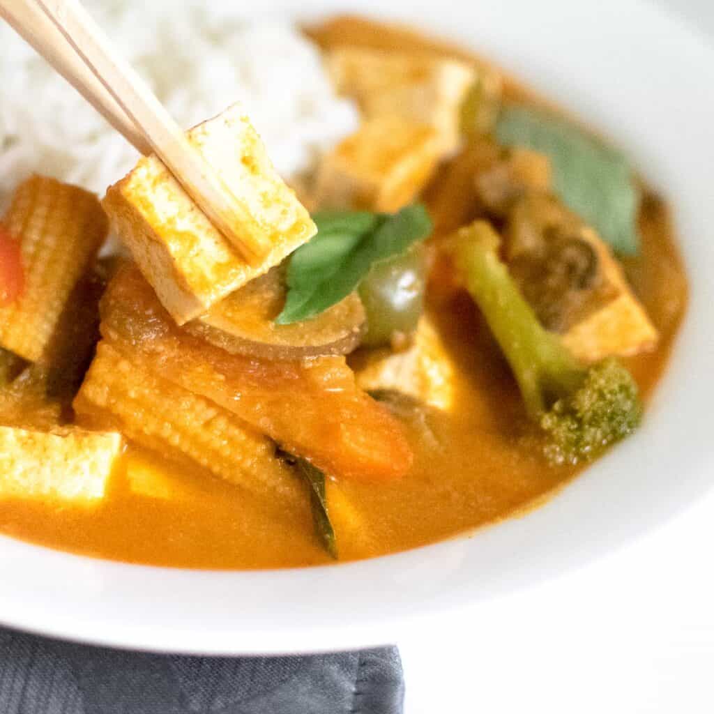 a chopstick picking up tofu.