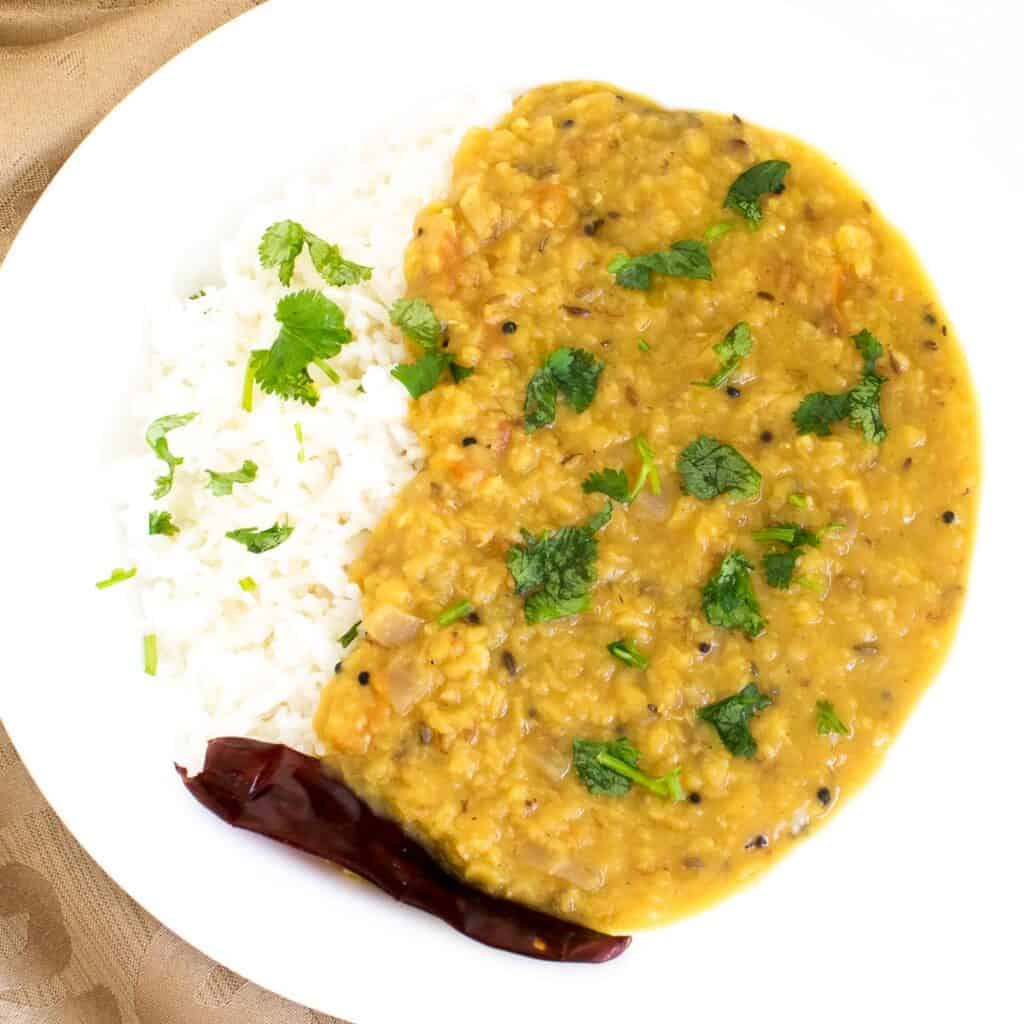 top view of red lentil dal in a serving plate.