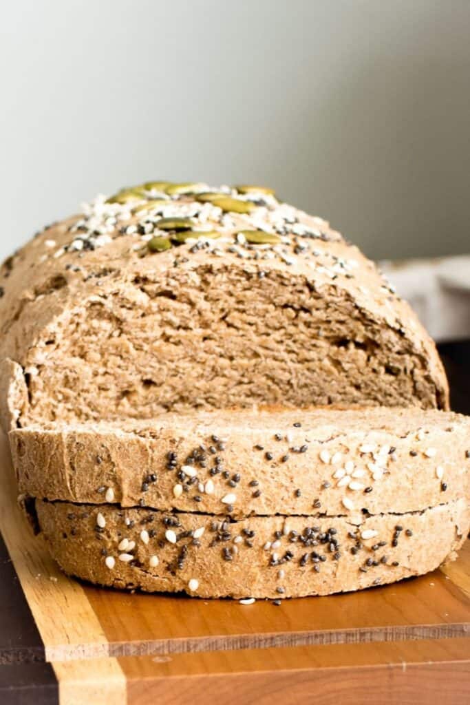 a front view of the sliced whole wheat bread on a wooden board.