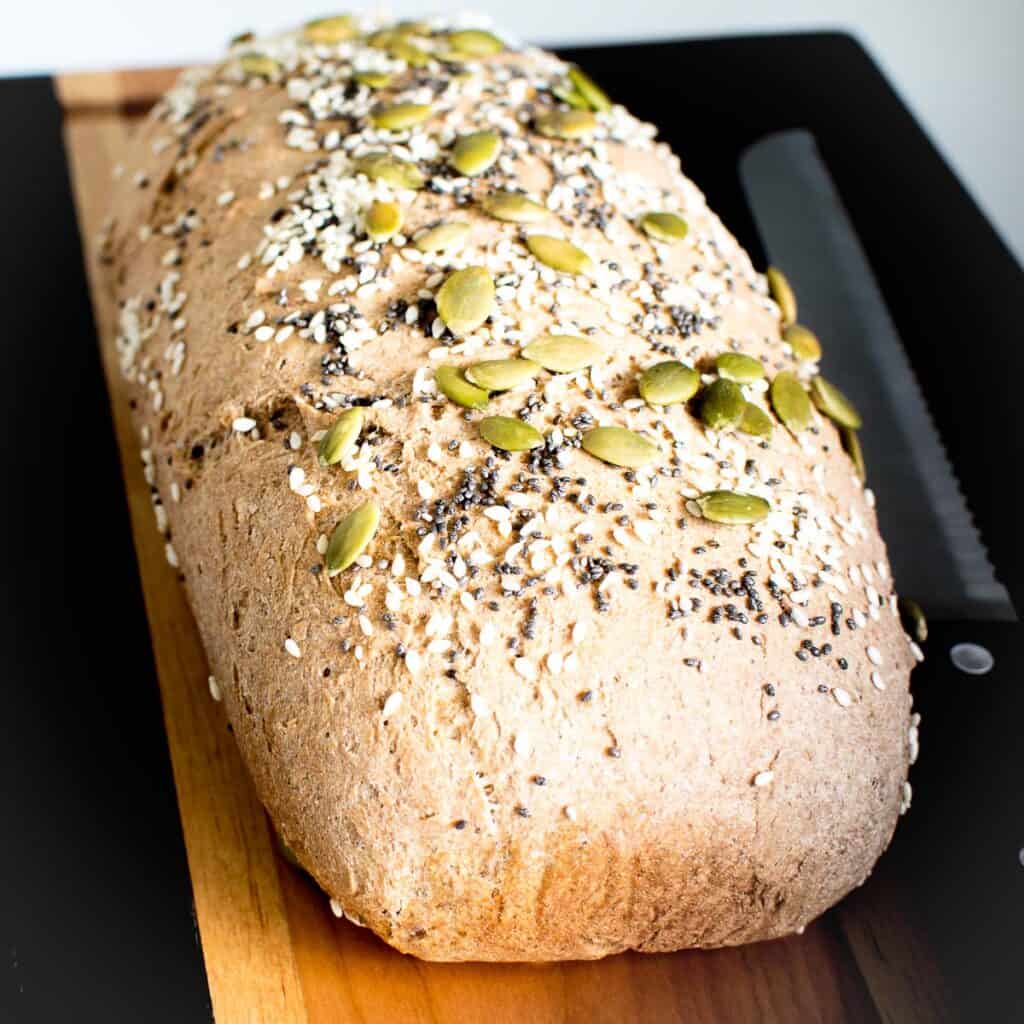 fresh baked whole wheat bread on a cutting board cooling down.