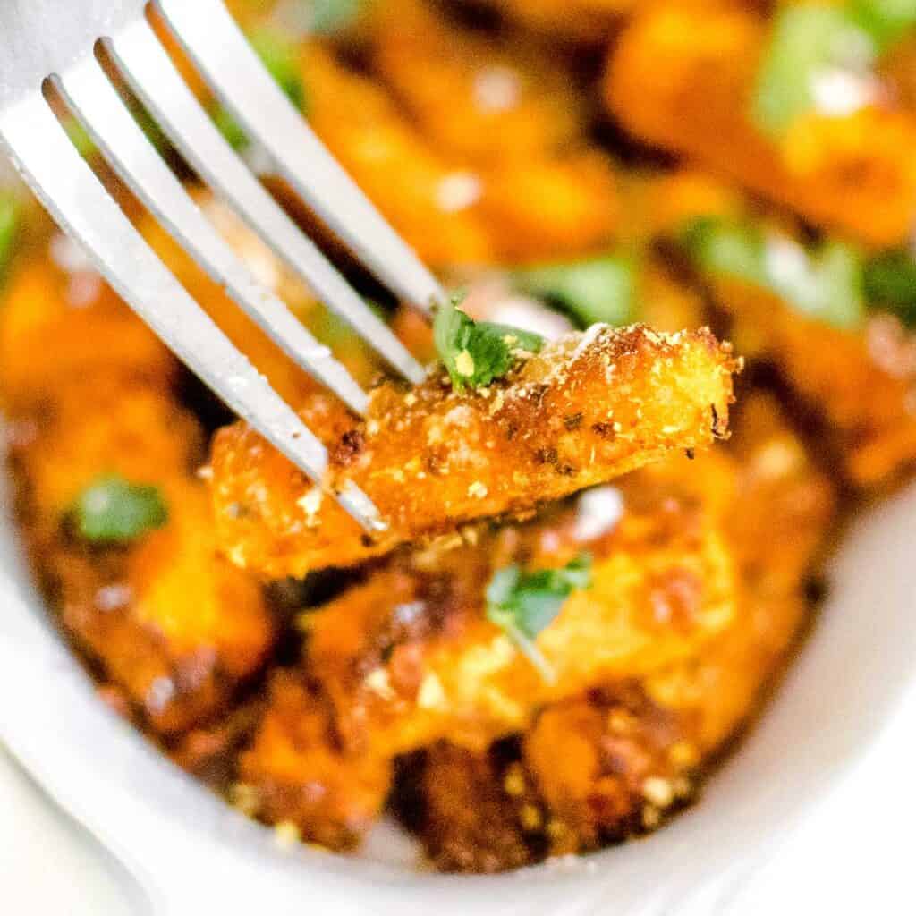 a fork lifting a piece of air fryer carrots.