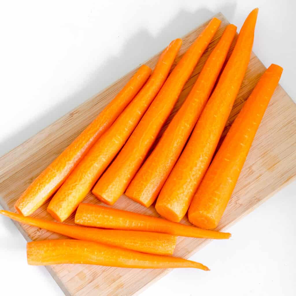 peeled carrots on a wooden board.