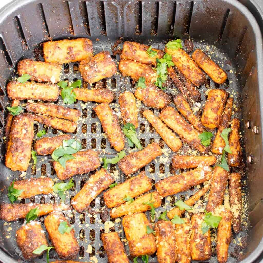 top view of air fryer carrots with the garnishes in the basket.