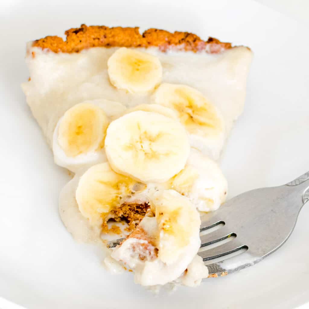sliced vegan banana cream pie with a fork with its piece.