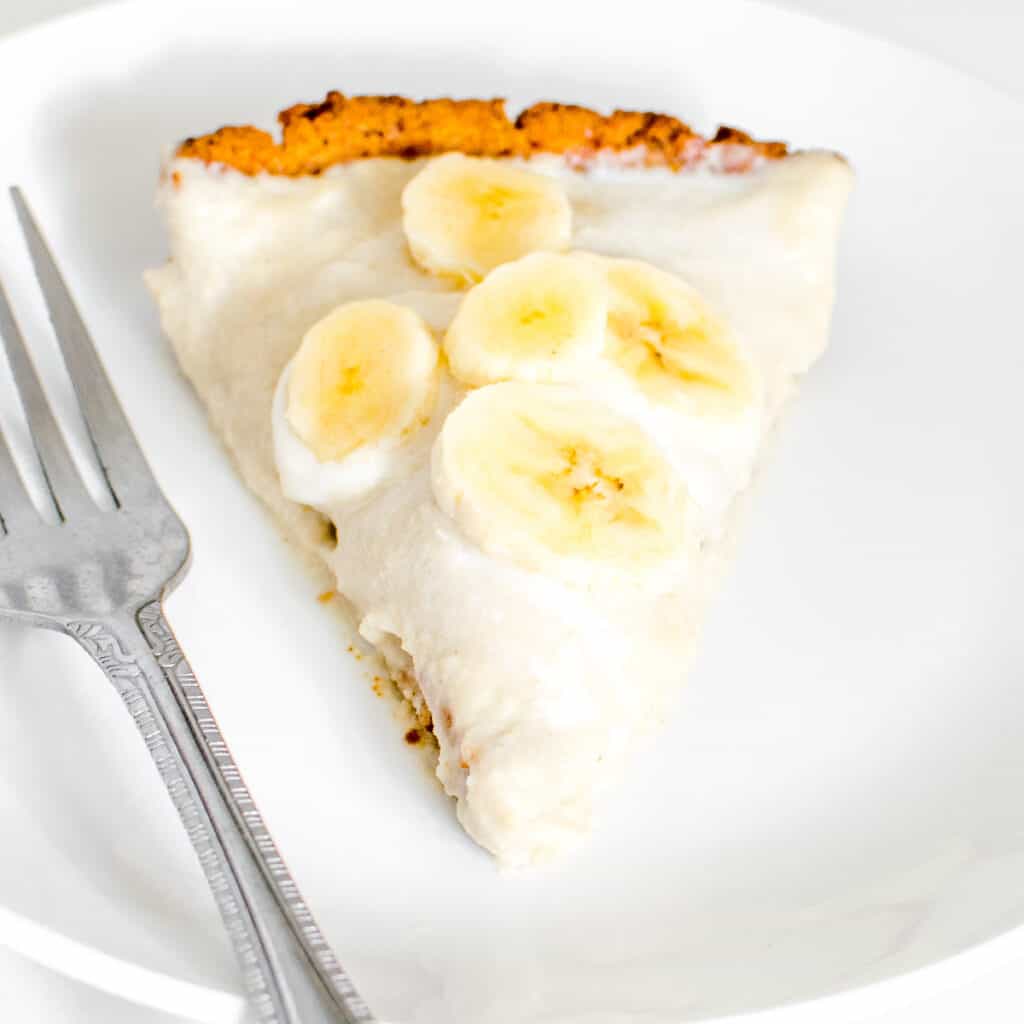 a close up 45 degree angle view of sliced vegan banana cream pie.