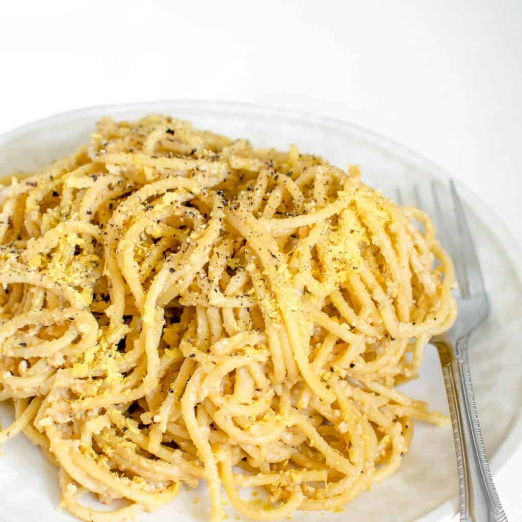 a close up view of vegan cacio e pepe in a serving plate.