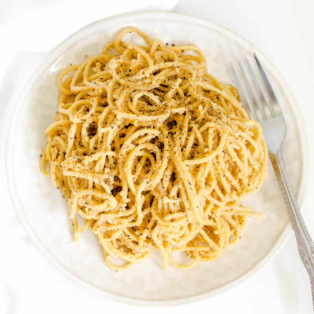 top view of vegan cacio e pepe in a serving plate.