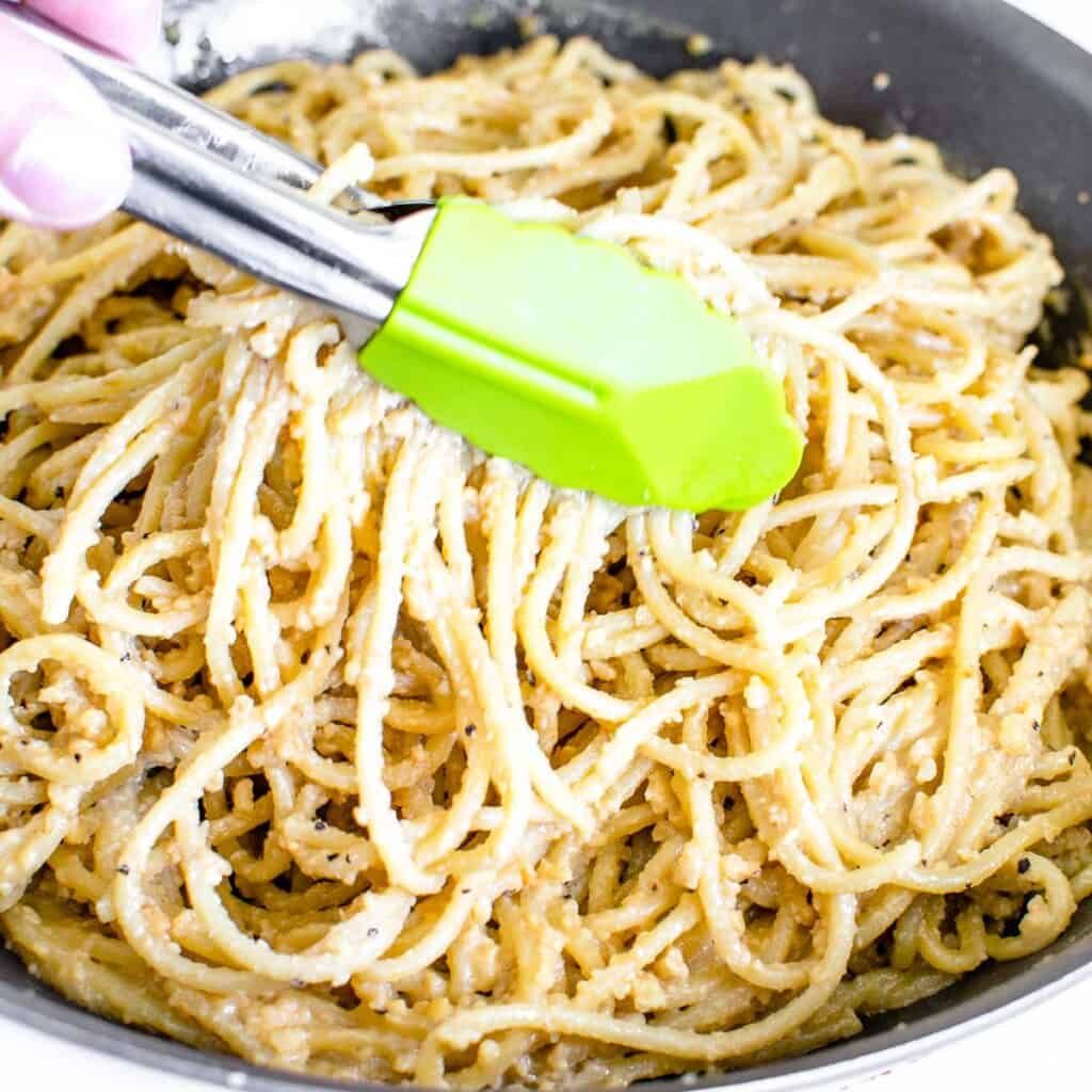 image showing the tongs tossing the pasta.