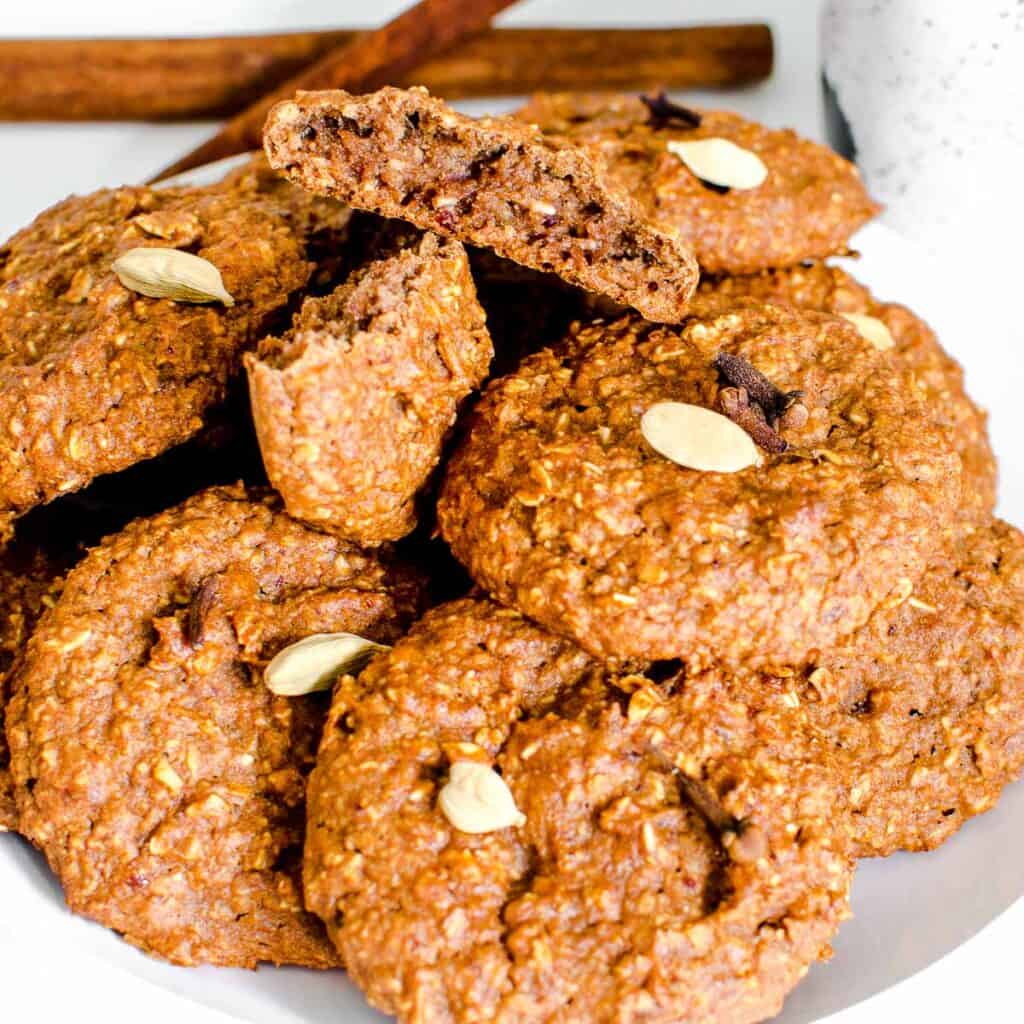 a close up view of broken chai cookie on a plate filled with more cookies.