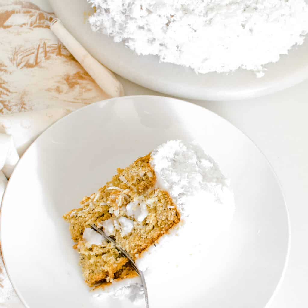 top view of a fork digging through a slice of vegan coconut cake.