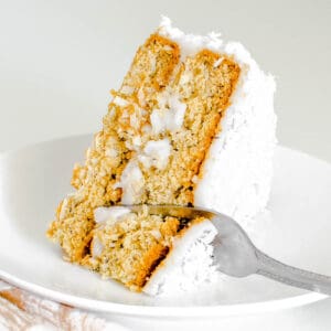 a fork digging through a slice of vegan coconut cake cake.