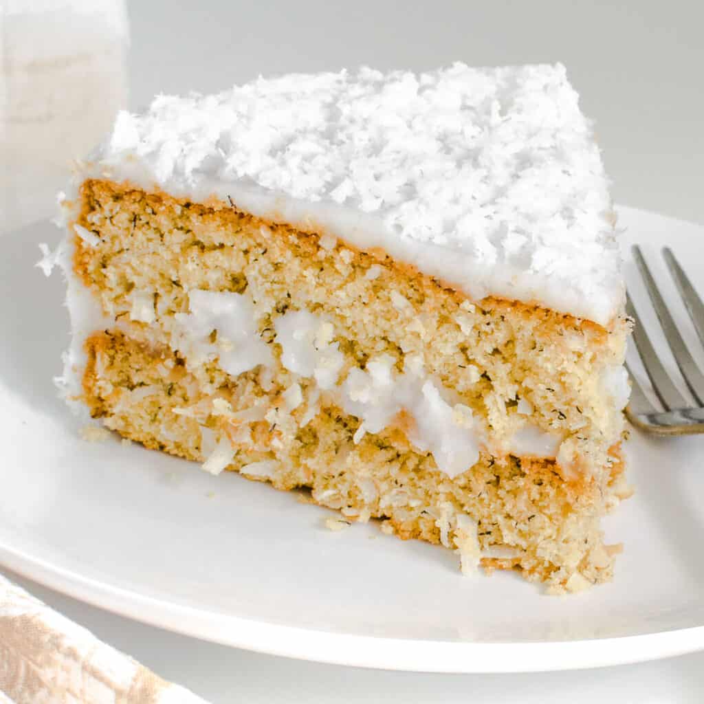 a close view of a slice of vegan coconut cake on a serving plate.