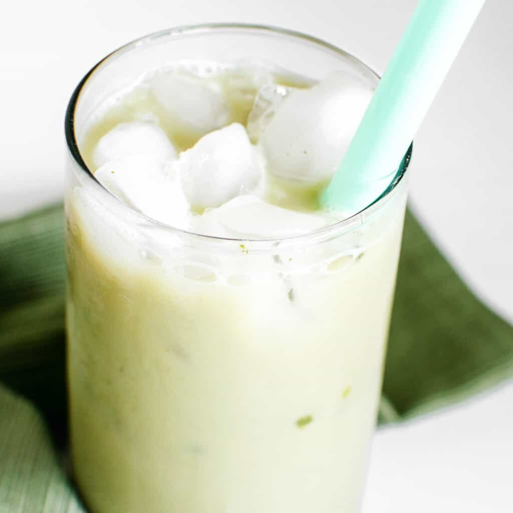 a close up view of iced matcha latte in a serving glass.