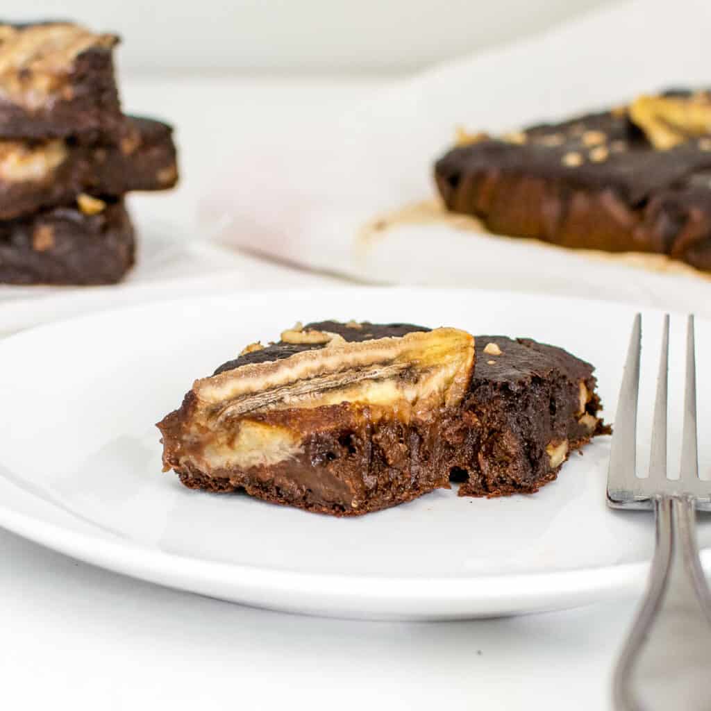 a front view of half eaten banana brownies in a serving plate.