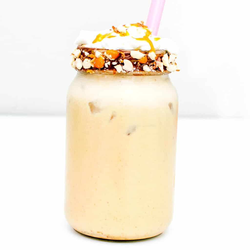 a tall glass jar with peanut butter milkshake.