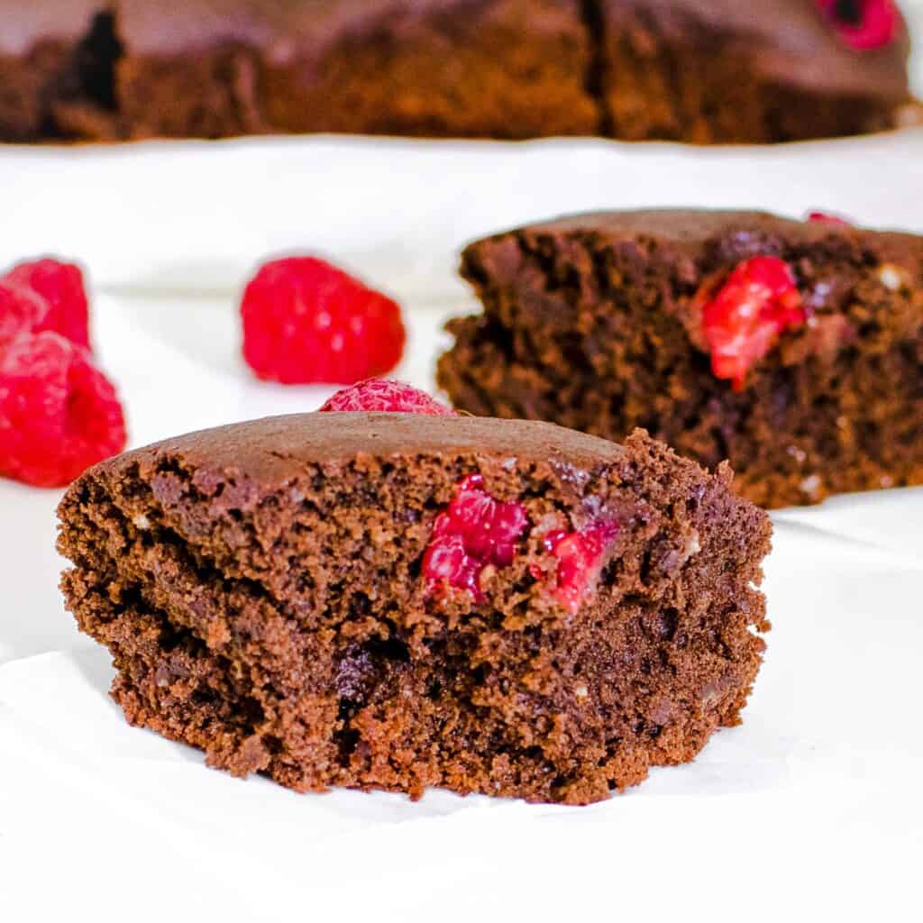 a front view of a slice of half eaten raspberry brownies.