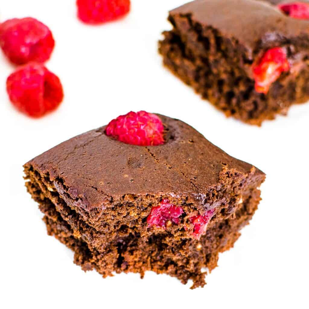 a 45 degree angle view of half eaten slice of raspberry brownies.