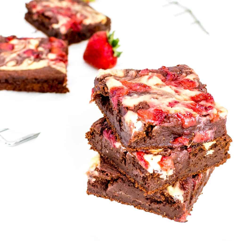 a 45 degree angle view of stacked strawberry cheesecake brownies.