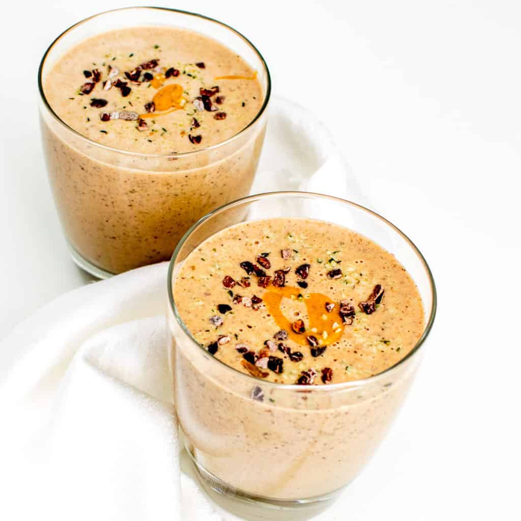 2 glasses filled with chocolate peanut butter smoothie.