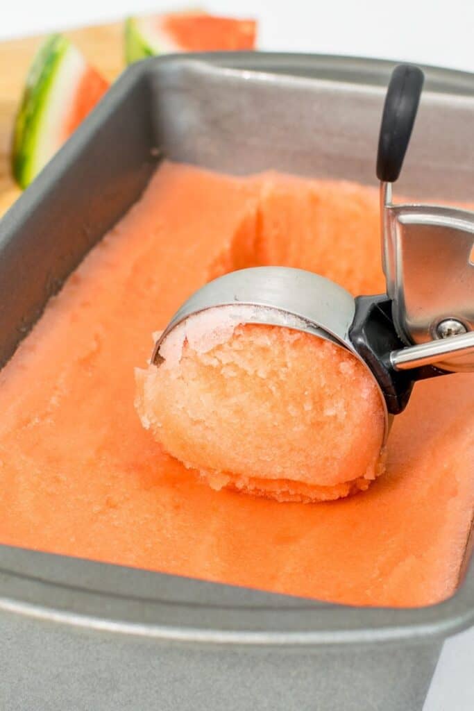 ice cream scoop in action of scooping watermelon ice cream.