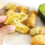 a hand showing close up of air fryer avocado fries