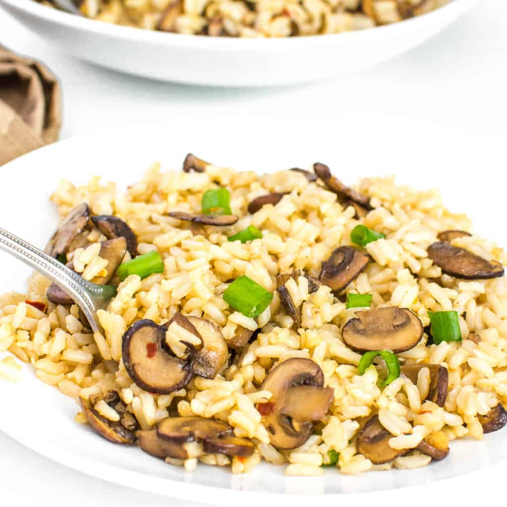 a fork digging into mushroom fried rice.