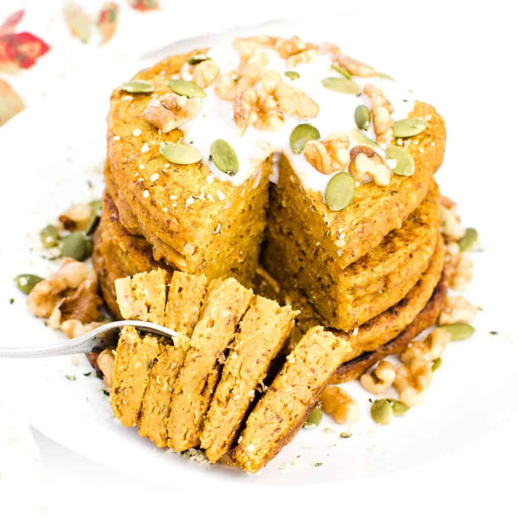 sliced pieces of vegan pumpkin pancakes with a fork.