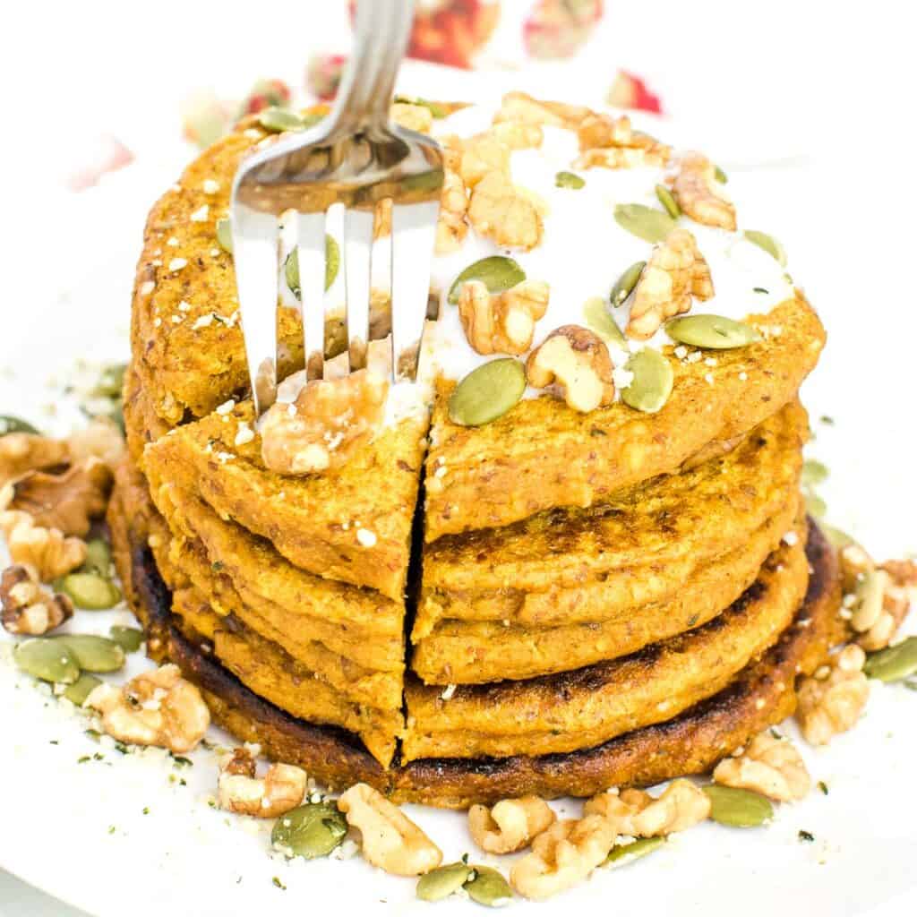 fork digging into the big stack of vegan pumpkin pancakes.