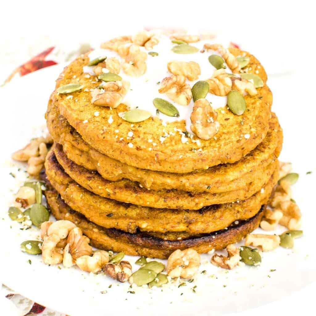 a 45 degree angle view of stacked vegan pumpkin pancakes.