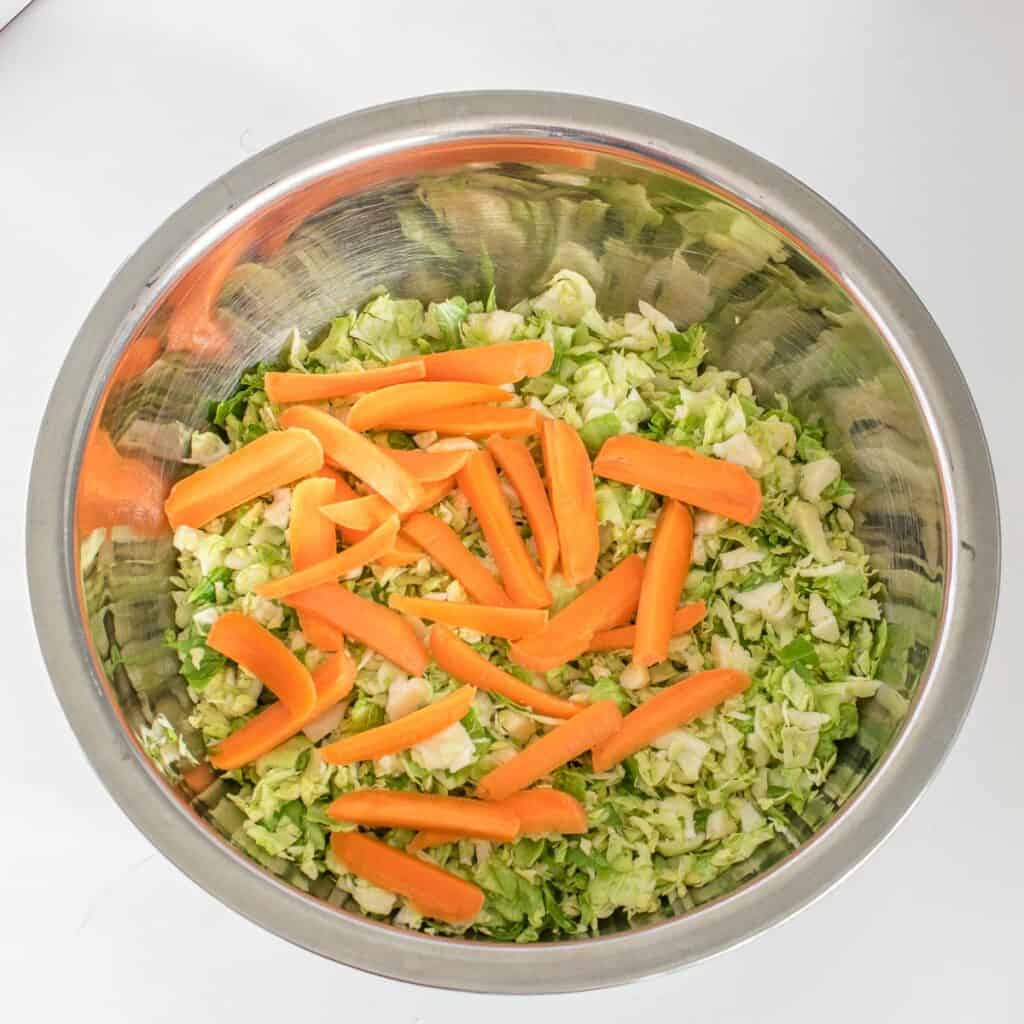 sliced carrots in the mixing bowl along with other ingredients.
